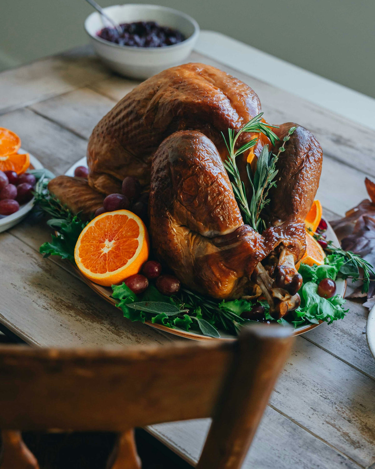 Golden roasted Thanksgiving turkey garnished with oranges and rosemary (serving suggestion)