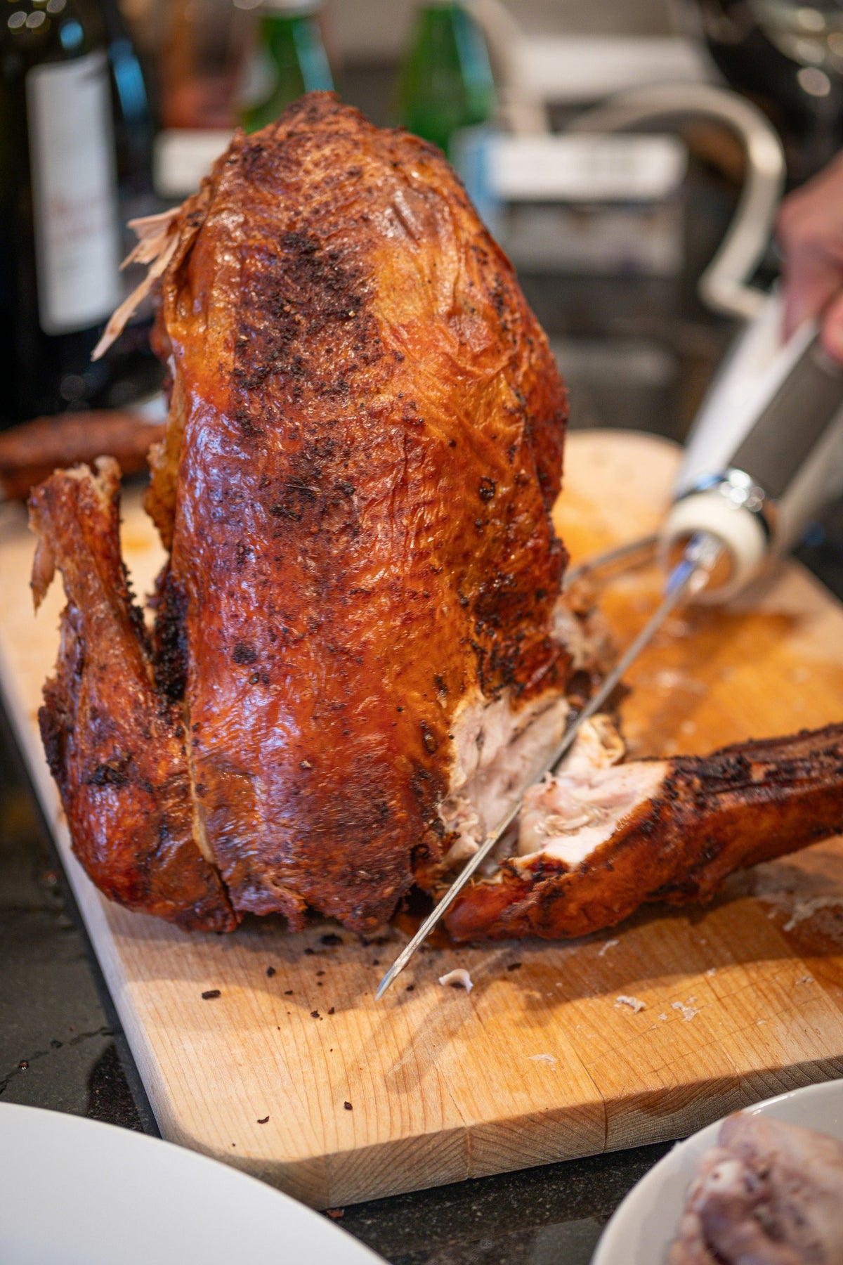 Roasted turkey being carved on a wooden board (serving suggestion)
